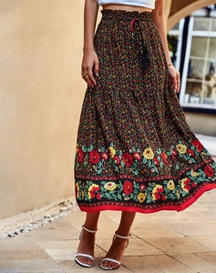 Détails de la jupe longue florale avec cordons à pompons et imprimé bohème sur l'ourlet
