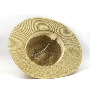 Detail of golden straw hat featuring spiral woven texture and adjustable inner sweatband