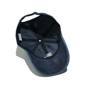Detail view of cotton sun hat interior with 100% cotton label and metal buckle