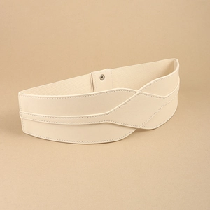 Detail of minimalist beige elastic waist belt with faux leather texture and snap closure