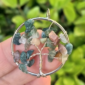 Macro shot of silver wire tree of life pendant featuring colorful natural stones