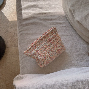 Dettaglio borsa trapuntata a fiori con etichetta simple wish su tessuto beige chiaro