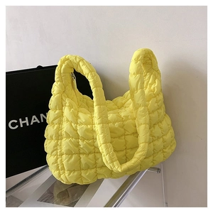 Detail of yellow quilted cloud hobo bag featuring soft pleated texture and wide strap