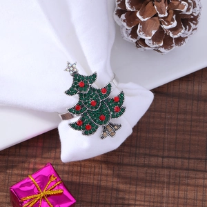 Christmas tree napkin ring with green and red rhinestones on a white fabric napkin