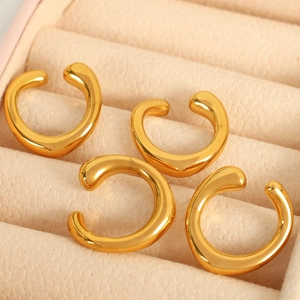 Minimalist gold-finish C-shaped ear cuffs set on beige velvet jewelry tray