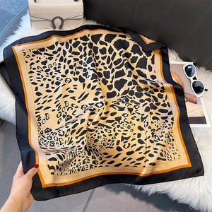 Elegant leopard print square silk scarf with orange border on a plush white background