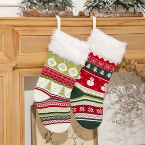 Calze di Natale in maglia con renne e fiocchi di neve appese al caminetto