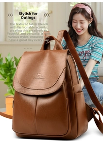 Detail of a brown leather backpack with kangaroo embossed logo and wide fabric strap