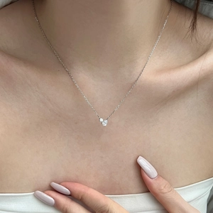 Close-up of a delicate S925 sterling silver necklace with double heart-shaped zircons