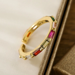 Elegant gold plated open ring with colorful zircon gemstones on a jewelry box