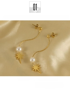 Detailed shot of gold titanium steel star drop earrings with white pearl and chain tassels