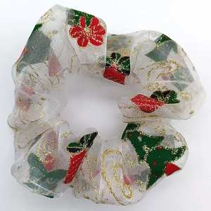 Detail of white mesh scrunchie with red and green Christmas prints and gold glitter edges
