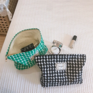 Detailed view of green and black polka dot makeup bags with Time to Party labels