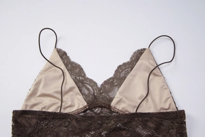 Détail de dentelle marron délicate avec doublure beige sur un caraco ajusté col V