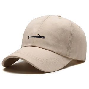 Minimalist beige cotton baseball cap with black whale embroidery on plain background
