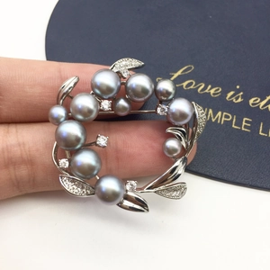 Detail of silver wreath brooch featuring grey freshwater pearls and crystal accents