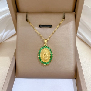 Macro view of gold oval portrait pendant necklace with emerald-green gems in gift box
