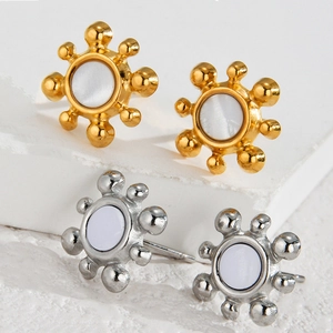 Macro shot of gold and silver irregular floral stud earrings with pearl-like inlay