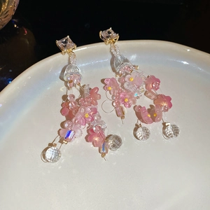 Detail of pink resin flower drop earrings with translucent beads on a white plate