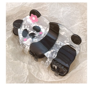 Detail of cute panda acetate hair claw clip showing glossy texture and pink flower accent