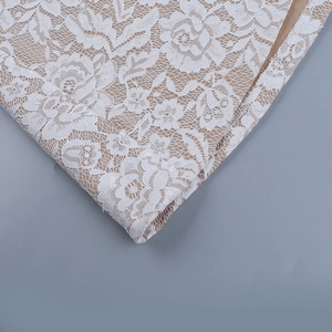 Close-up of intricate white floral lace embroidery with premium beige lining detail
