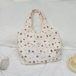 Détail du cabas en toile crème avec motifs d'ours en peluche et texture gaufrée moderne