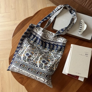 Détail d'un sac cabas en lin bohème avec imprimé ethnique sur une table en bois