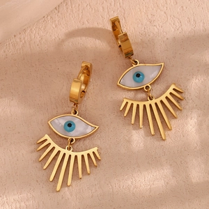 Vue macro des boucles d'oreilles œil porte-bonheur dorées 18K avec nacre et cils suspendus