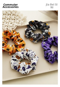 Set of four Halloween hair scrunchies with pumpkin bat and ghost prints on a tray
