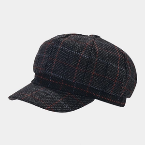 Dettaglio del berretto retrò britannico a quadri con trama in tessuto tweed rosso e grigio