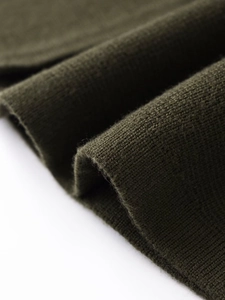 Gros plan sur un tissu en maille vert olive montrant une texture fine et élégante
