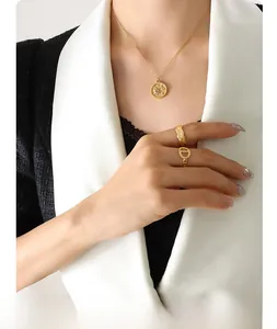 Close-up of gold sun and moon pendant necklace with link and rope textured rings