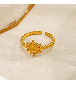 Detailed close-up of 18K gold plated sun flower ring on elegant cream fabric