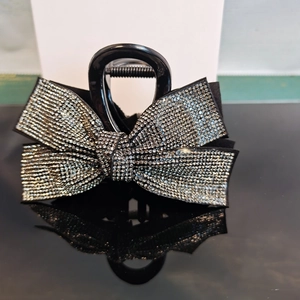 Macro shot of a black bow claw clip with shimmering rhinestones and reflection