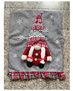 Detailed close-up of a burlap Christmas chair cover featuring a gnome with white braids