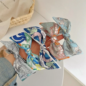 Detail shot of elegant silk-like bow headbands with colorful floral prints