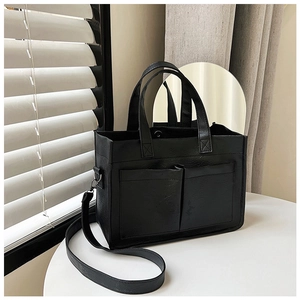 Detail of black PU leather tote with front pockets and detachable shoulder strap