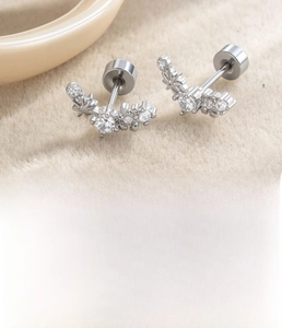 Detailed view of silver titanium steel curved stud earrings with star cubic zirconia