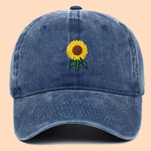 Close-up of sunflower embroidery on washed denim blue cotton baseball cap crown