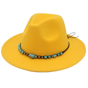 Detailed close-up of yellow felt fedora hat with turquoise beads and golden ornaments band