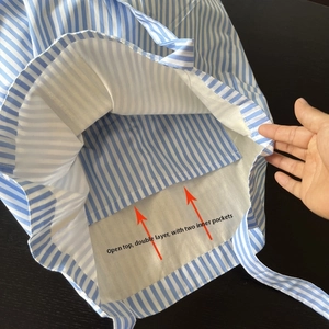 Dettaglio interno che mostra le doppie tasche interne aperte della borsa a righe