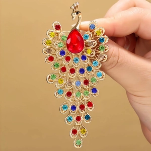 Exquisite gold peacock brooch with colorful rhinestones and a large red drop gemstone