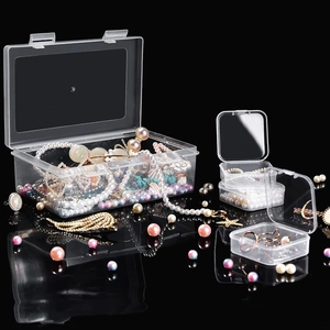 Macro detail of transparent plastic organizer boxes with beads on a black background
