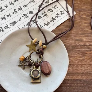 Gros plan détaillé du pendentif appareil photo rétro et des perles en bois du collier vintage