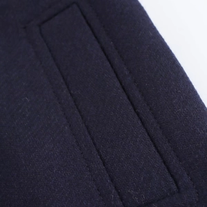 Detail of premium navy blue wool blend fabric with professional double stitching lines