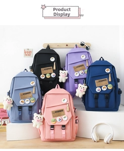 Multiple nylon backpacks in five colors displayed with bear charms and decorative badges