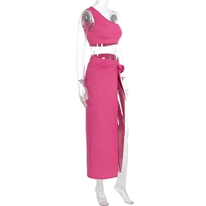 Détails du crop top asymétrique et de la jupe longue fendue à nouer rose fuchsia
