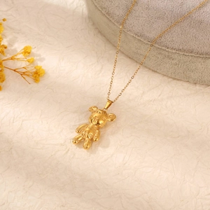 Detail of 18K gold plated teddy bear pendant with Love & Peace engraving on jewelry box