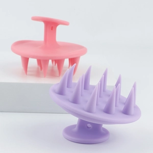Détail des brosses de massage du cuir chevelu en silicone rose et violet avec poignée ergonomique