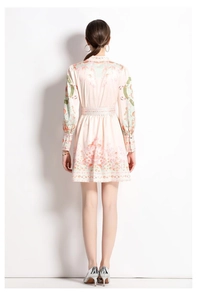 Back view of a long-sleeve floral dress with cinched waist and French retro shell patterns